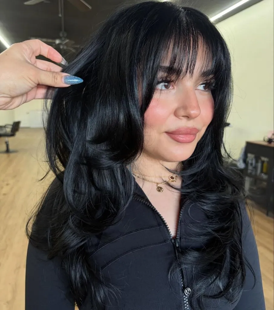 Fall Haircuts for Women 2026 Jet Black Voluminous Waves With Wispy Fringe