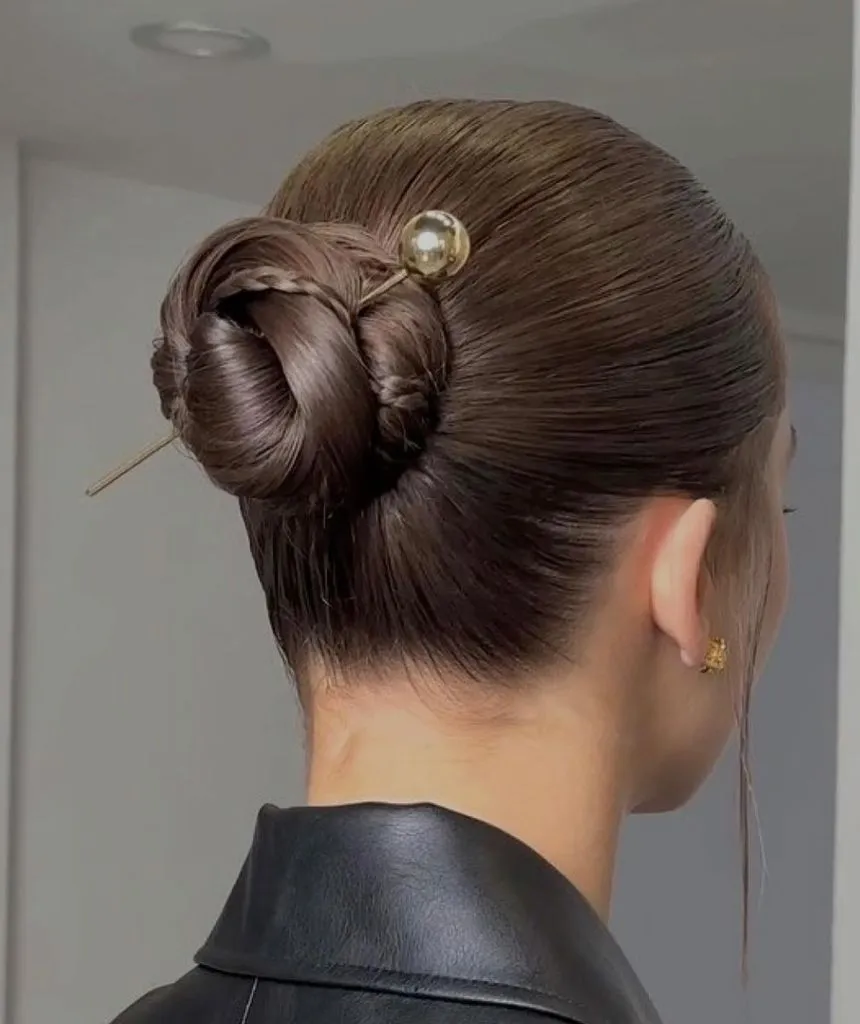 Fall Hairstyles for Office 2026 Glossy Twisted Chignon with Gold Hair Pin Accent