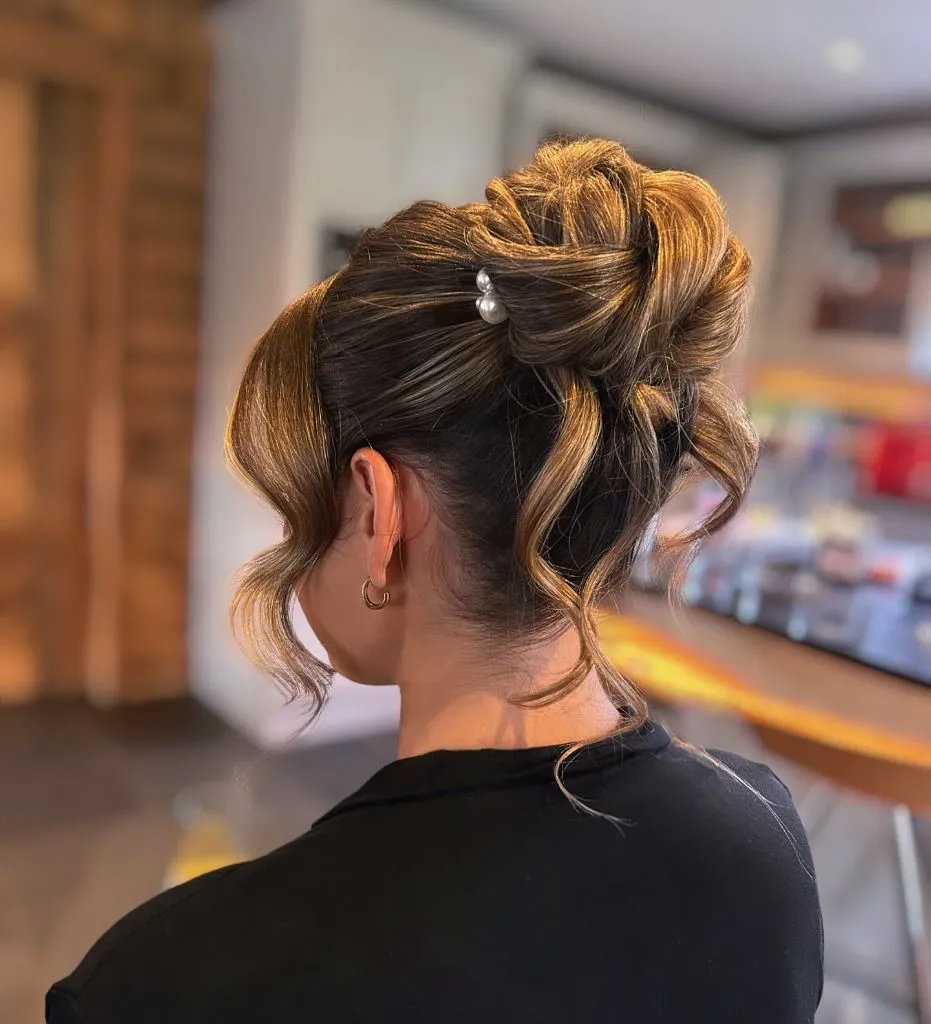 Fall Hairstyles for Wedding Guests 2026 Textured High Bun with Pearl Pin and Loose Tendrils