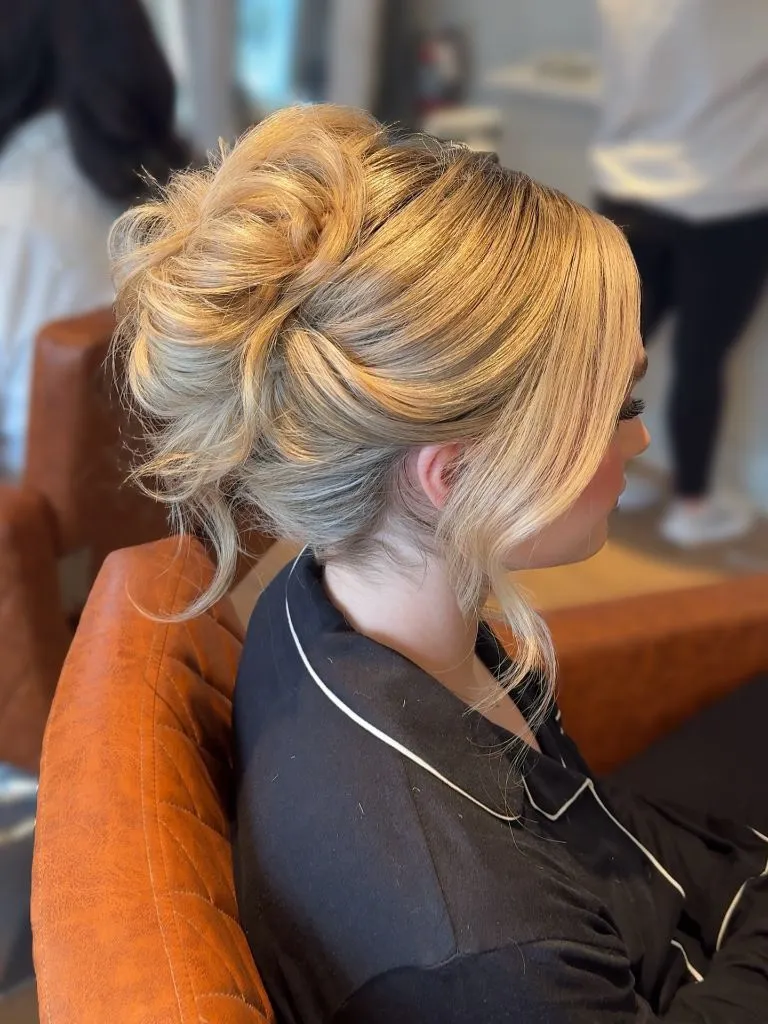 Fall Hairstyles for Wedding Guests 2026 Voluminous Blonde French Twist Updo with Soft Movement