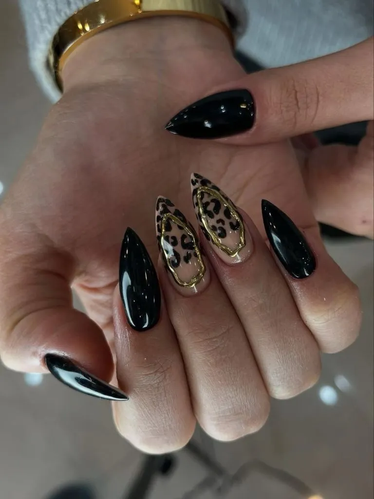 August Nails Ideas 2026 Black Stiletto Nails With Gold-Outlined Leopard Accent Design