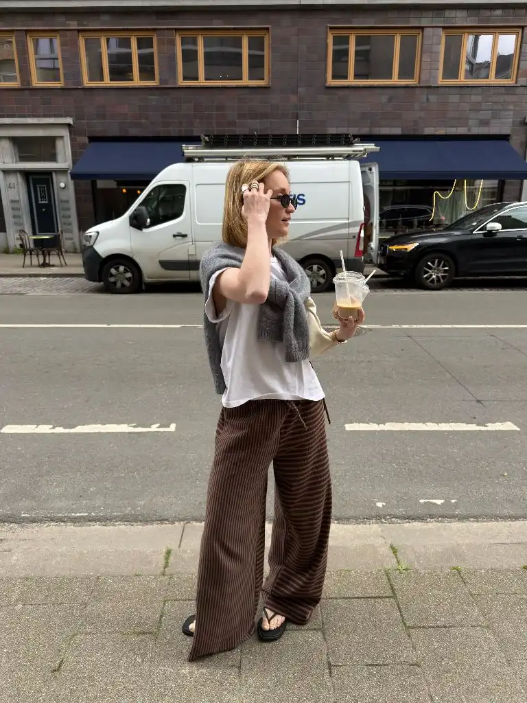 August Outfits 2026 White Tee and Brown Striped Trousers With Grey Sweater Draped