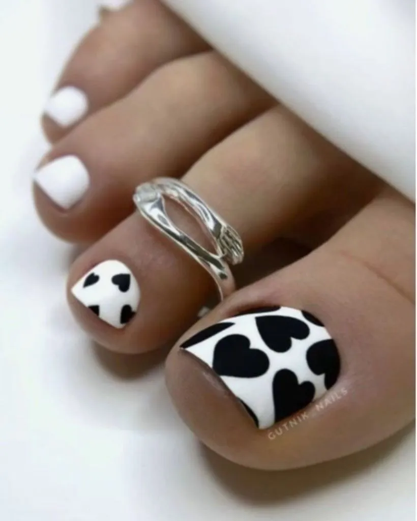 August Pedicure Nails Ideas 2026 Black and White Heart Cow-Print Toes for a Graphic Bold Finish