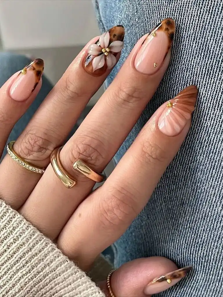 August Nails Ideas 2026 Tortoiseshell French Tips With Floral Accent on Nude Almond Nails