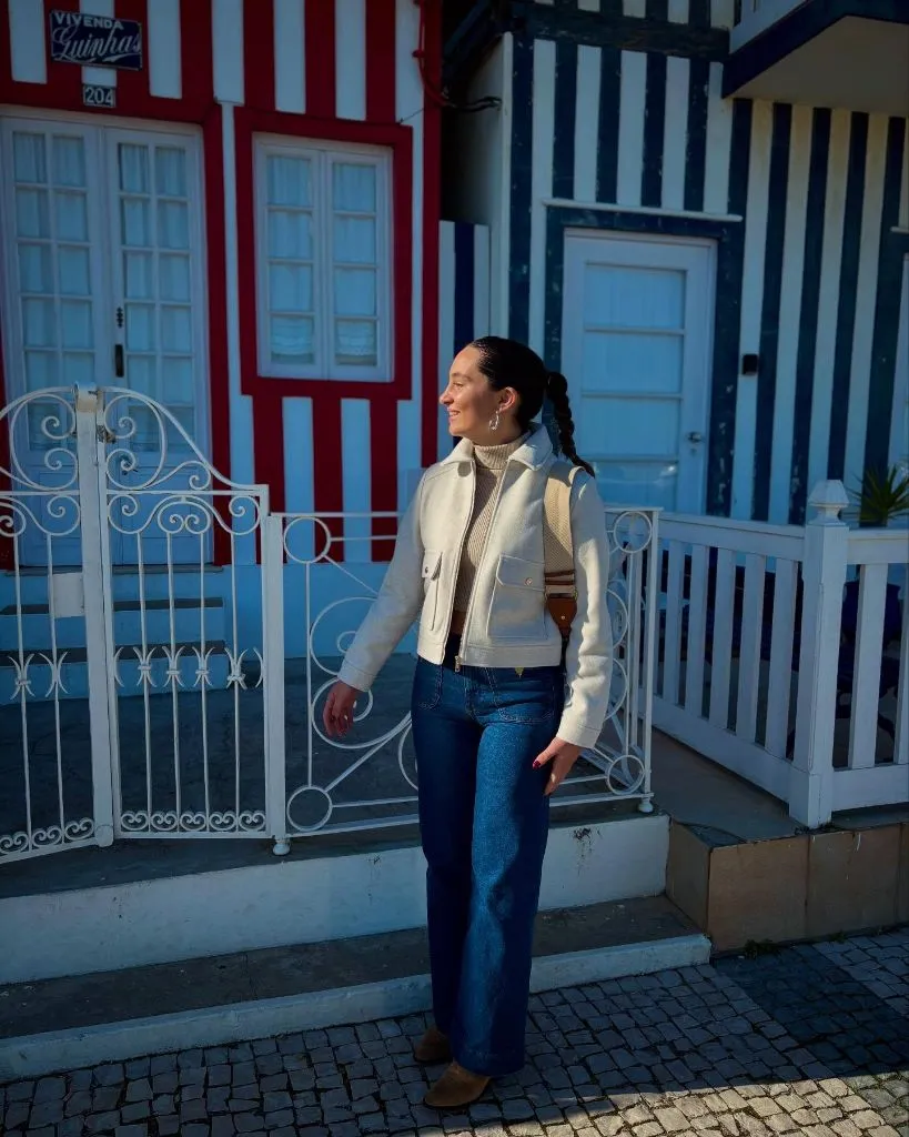 Fall Travel Outfits 2026 Cream Wool Vest Over Turtleneck With Portuguese Tile Vibes