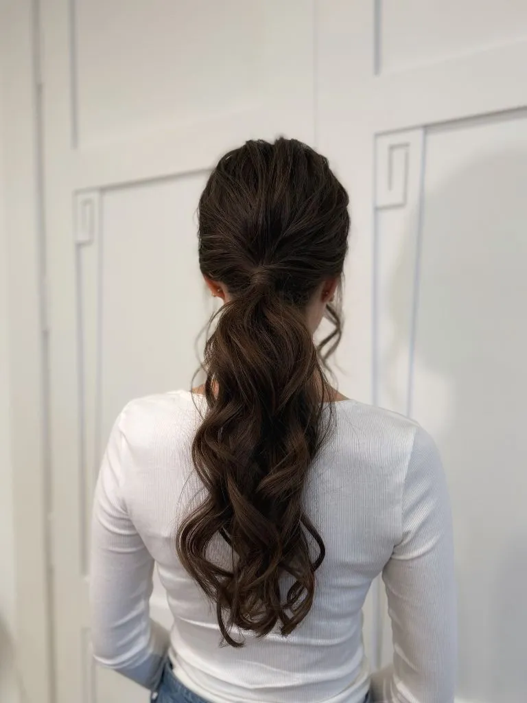 Fall Hairstyles for Wedding Guests 2026 Textured Low Ponytail with Soft Bouncy Waves
