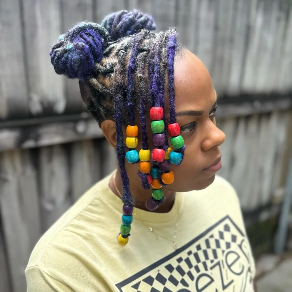 Locs Hairstyles for Black Women 2026 Purple Locs with Rainbow Beaded Accents and Top Knot