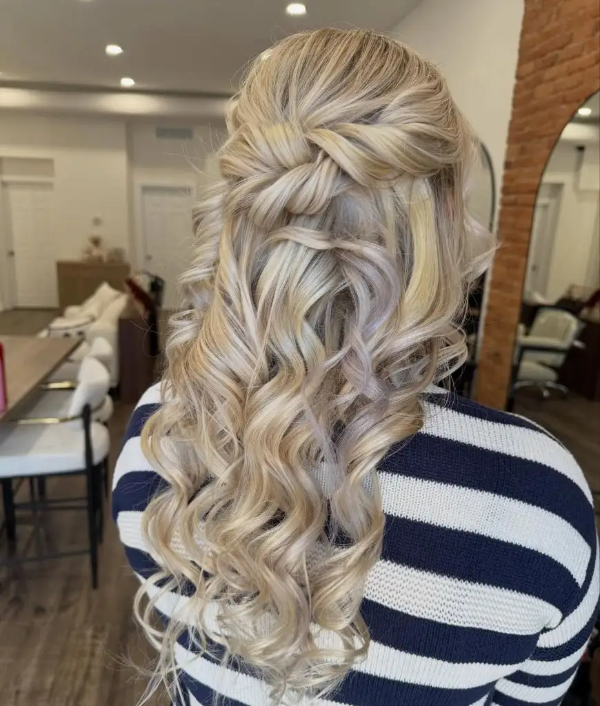 Fall Hairstyles for Wedding Guests 2026 Blonde Waterfall Half-Up with Glossy Spiral Curls