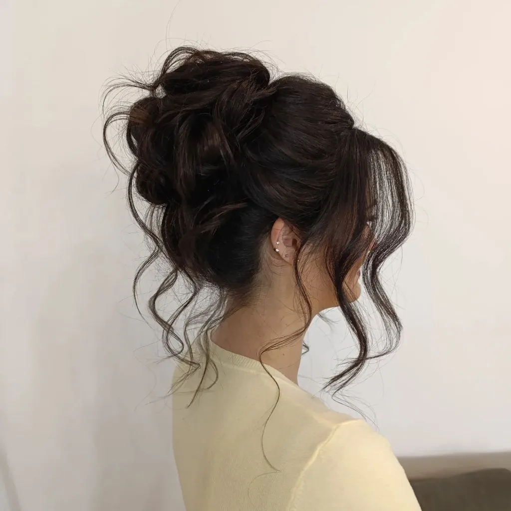 Fall Hairstyles for Office 2026 Voluminous Messy High Bun with Dark Curly Texture