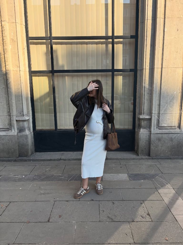 Fall Pregnancy Outfits 2026 Ivory Midi Dress With a Brown Leather Jacket and Adidas Sambas