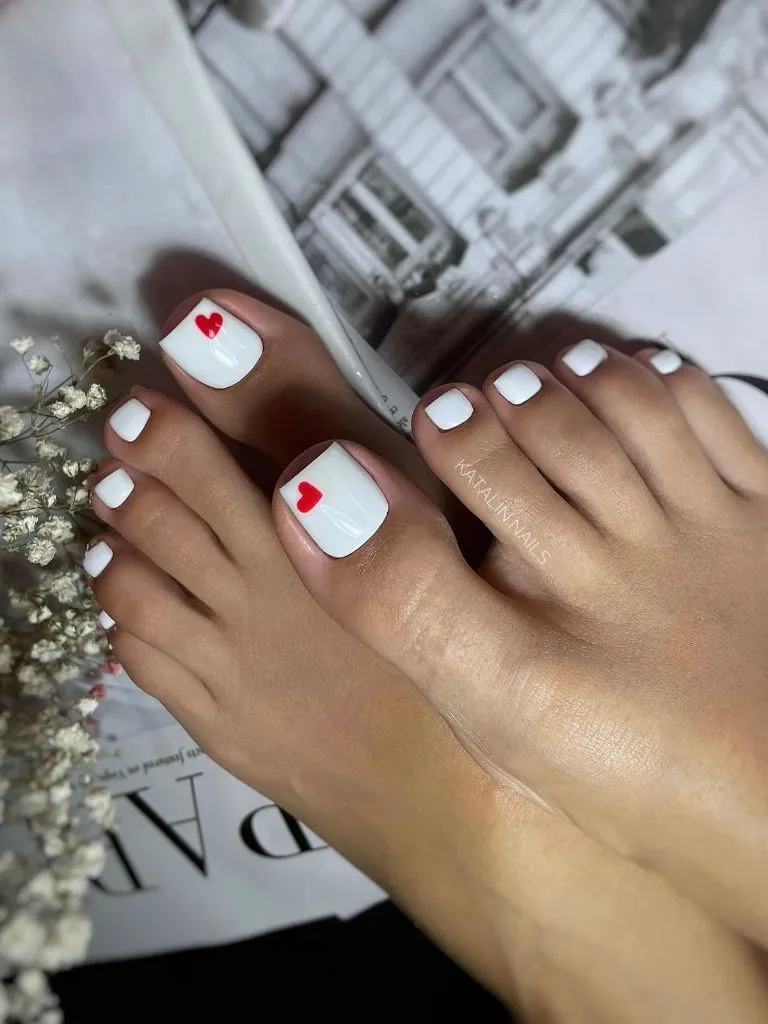 August Pedicure Nails Ideas 2026 White Toes With Small Red Heart Accents for a Romantic August Detail