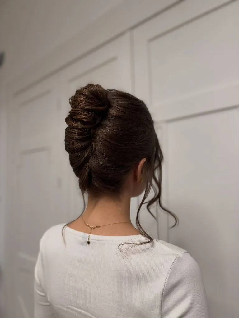 Fall Hairstyles for Wedding Guests 2026 Sleek Brunette French Twist with Soft Tendrils