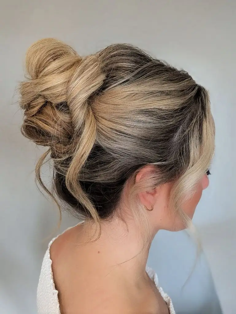 Fall Hairstyles for Wedding Guests 2026 Blonde French Twist Updo with Airy Loose Tendrils