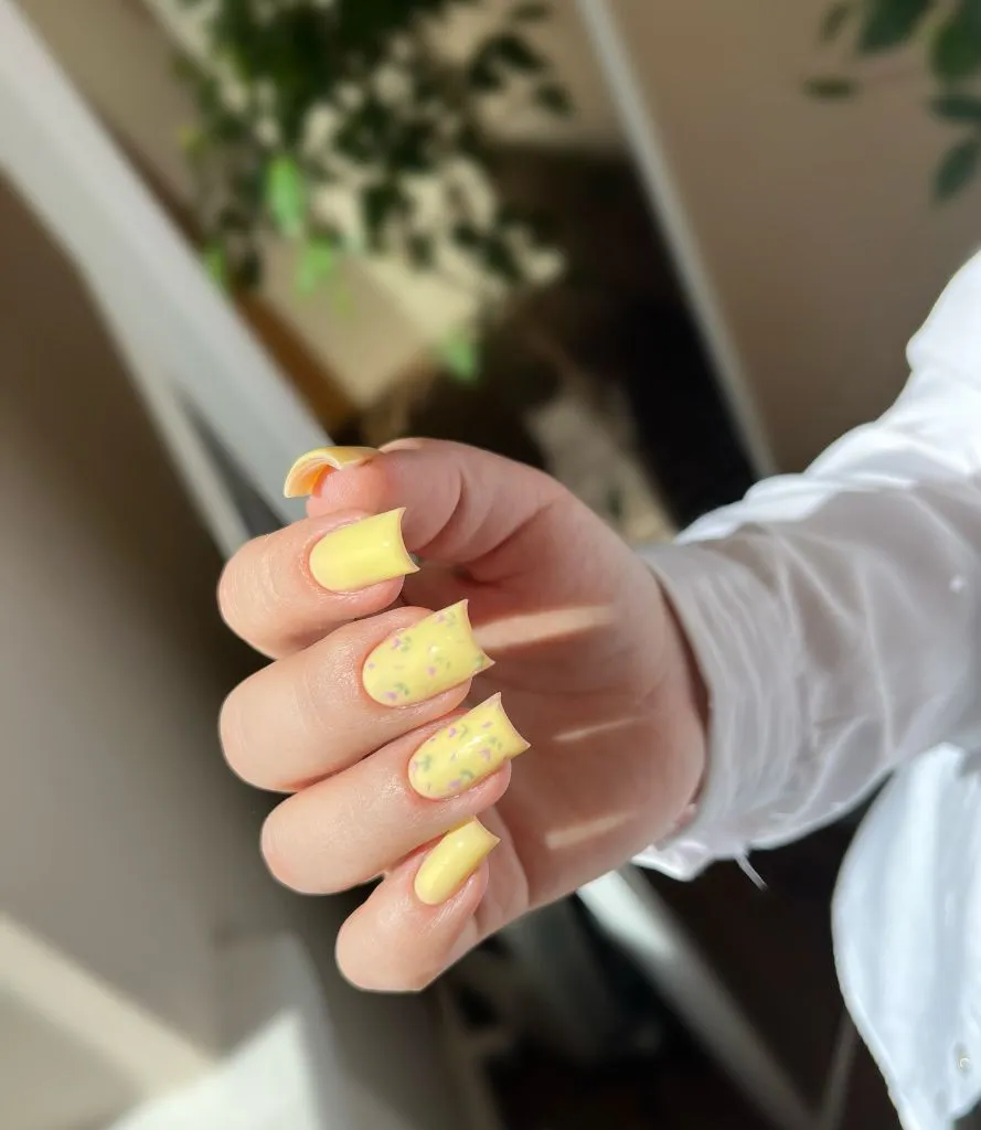 Fall Medium Nail Ideas 2026 Pastel Yellow Square Nails With Scattered Floral Sprinkle Detail