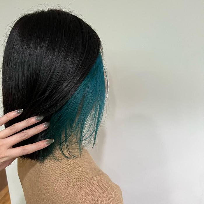 Teal dip-dyed ends on long dark hair
