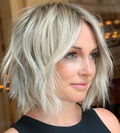 Platinum shaggy bob haircut with choppy layers and curtain bangs
