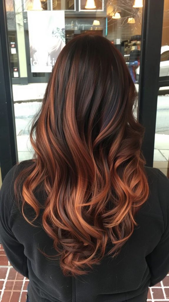 Brown balayage hair with curtain bangs and warm copper highlights