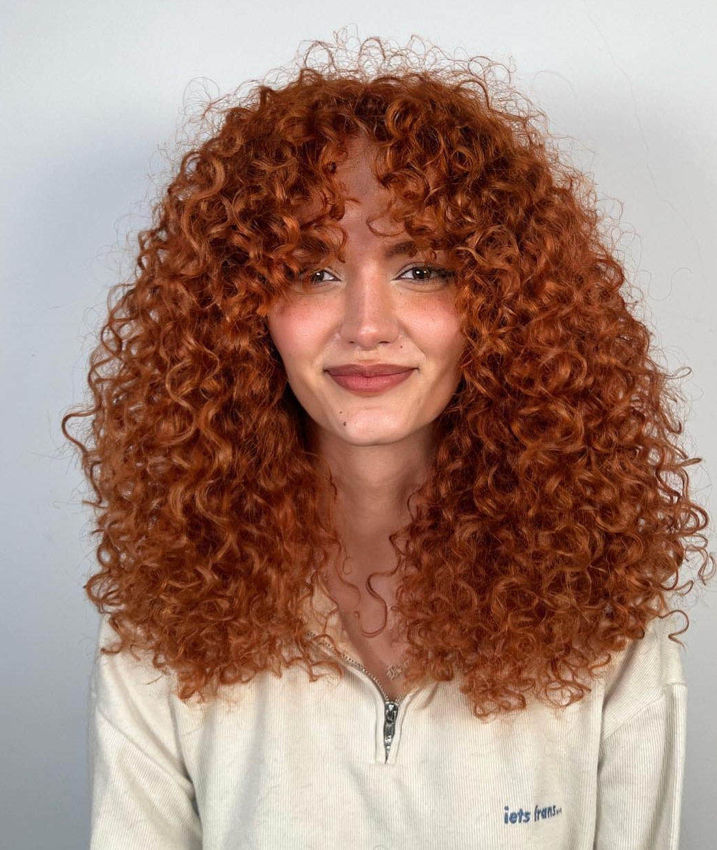 Center-parted red curls with a lighter fringe