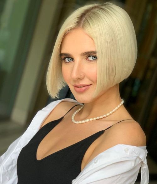 Short blonde bob haircut with center parting