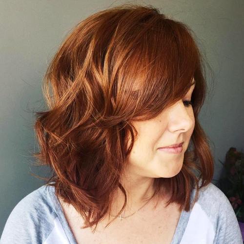 Medium chestnut brown wavy hairstyle with a sweeping side fringe