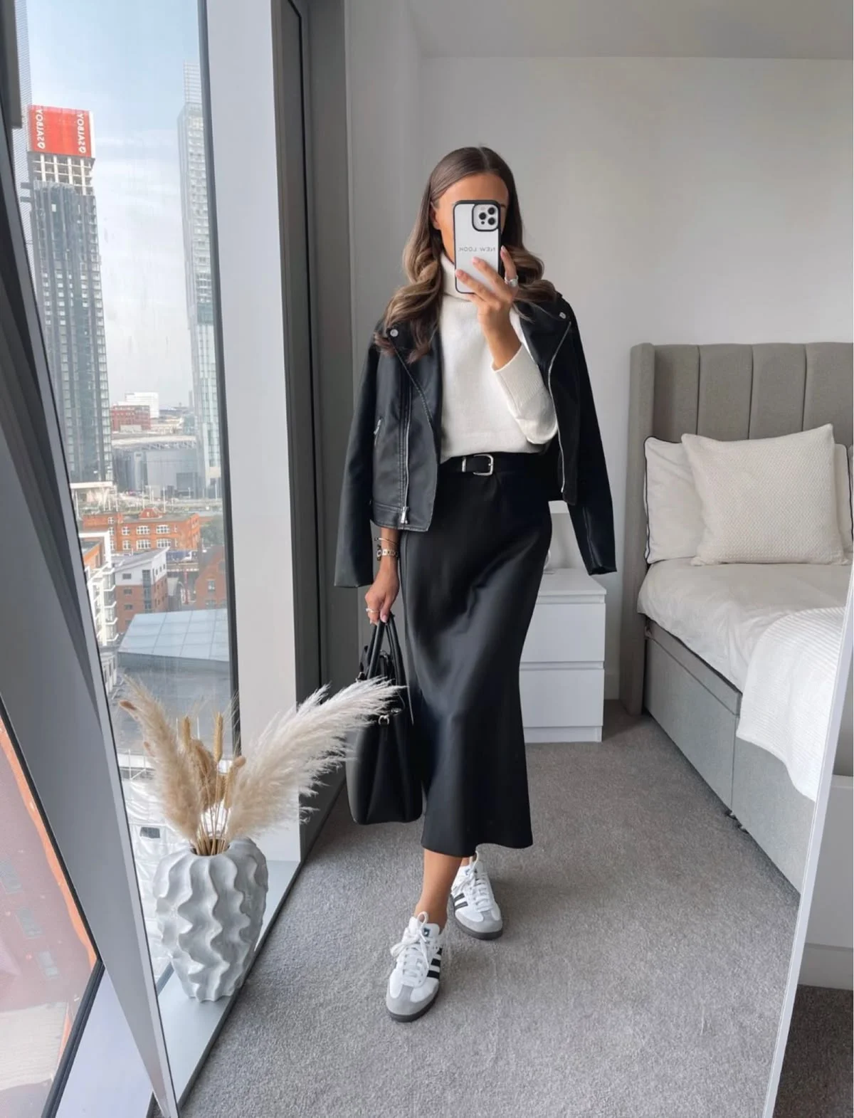 Leather biker jacket, white turtleneck and flowing black satin skirt outfit