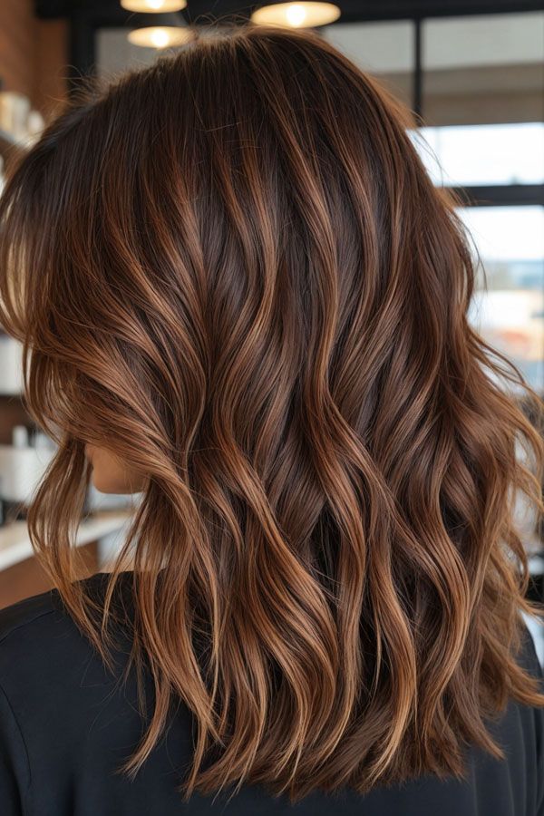 Woman with chestnut brown hair and warm highlights