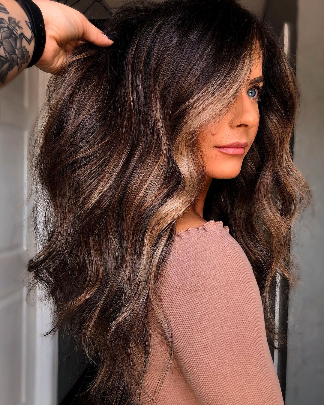 Face-framing candlelit highlights on layered dark brown hair