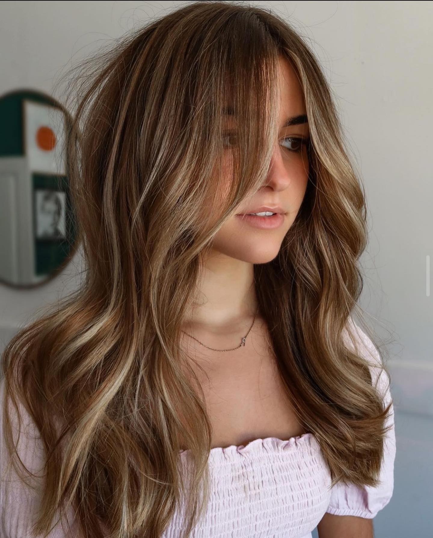 Gentle blonde strokes as partial highlights on straight brown hair