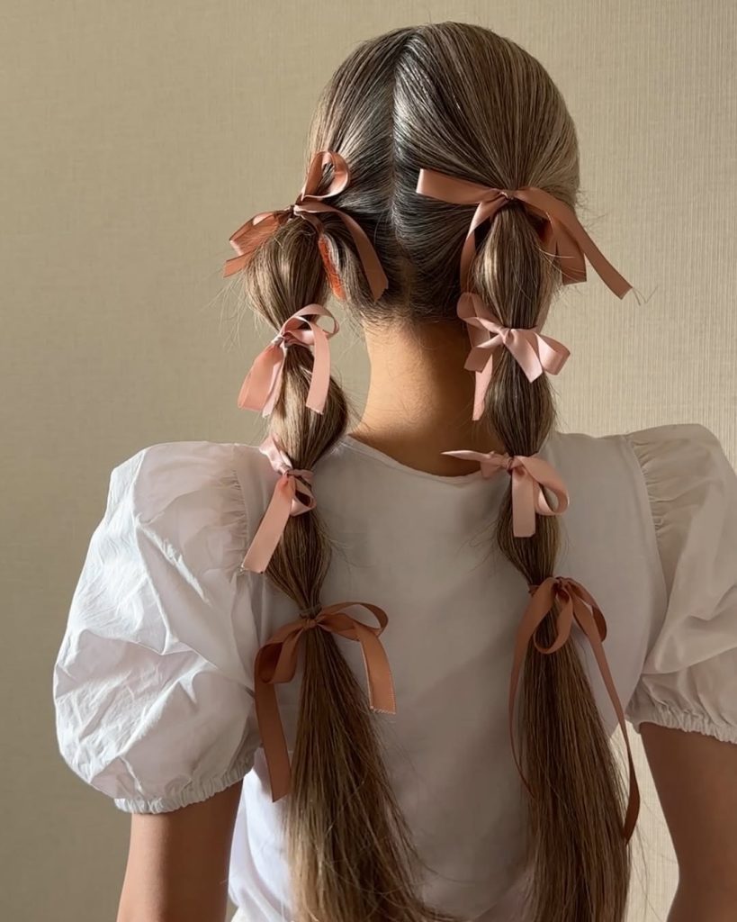 Low pigtails tied with ribbon bows