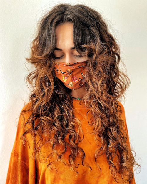 Long highlighted curls with curtain bangs