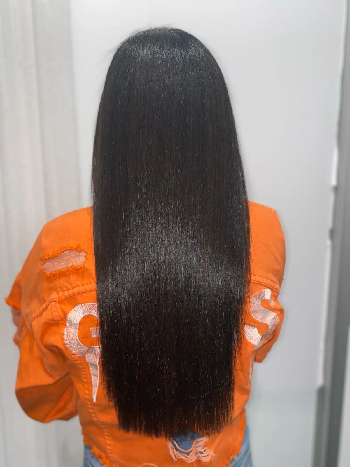 Long straight layered hair with a high-shine silk press finish