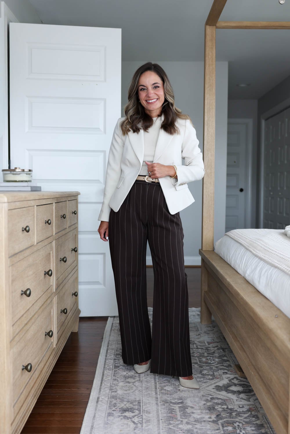 Chocolate brown trousers with a taupe top, a blazer and a belt.