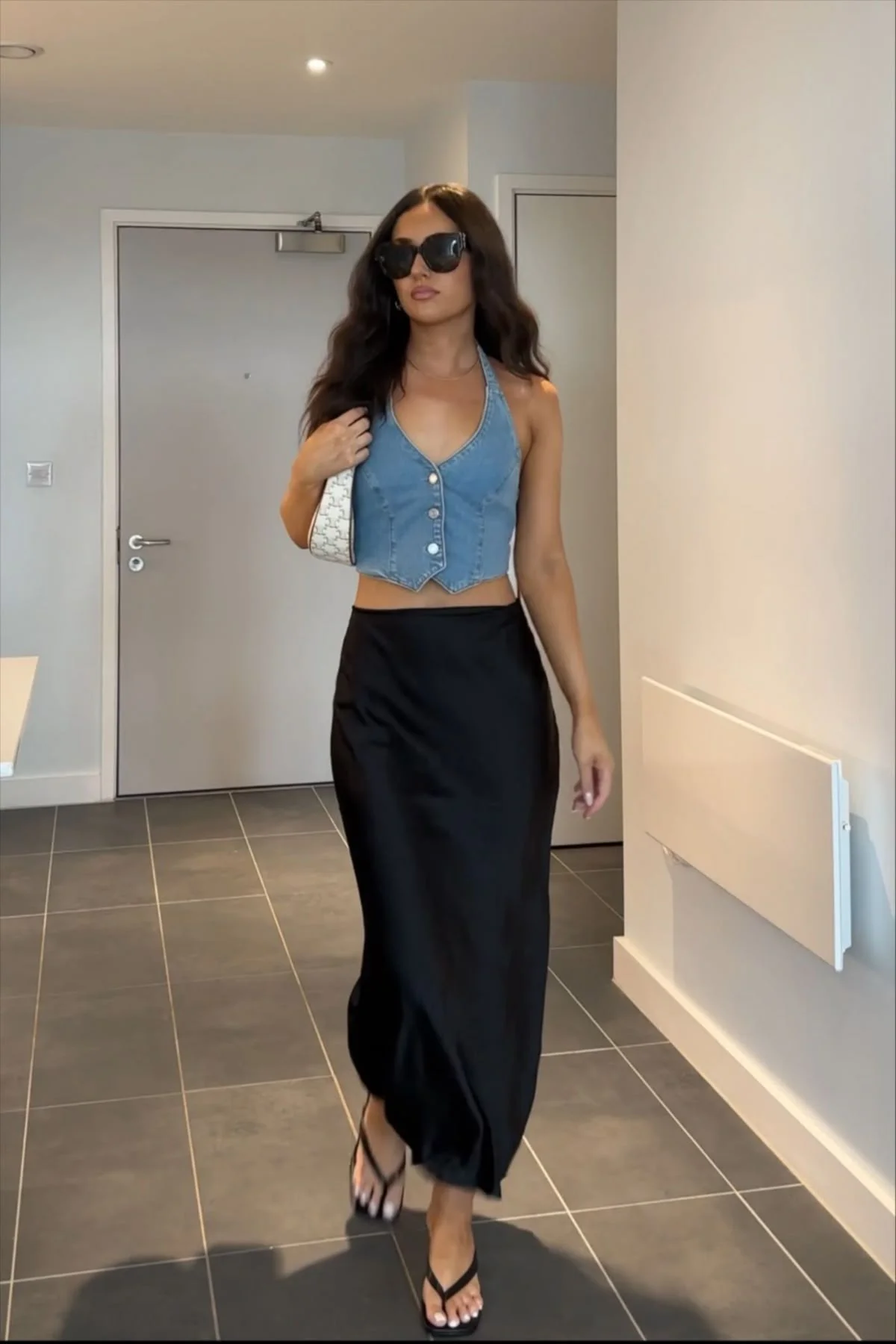 Denim halter top and flip-flops with black satin skirt outfit