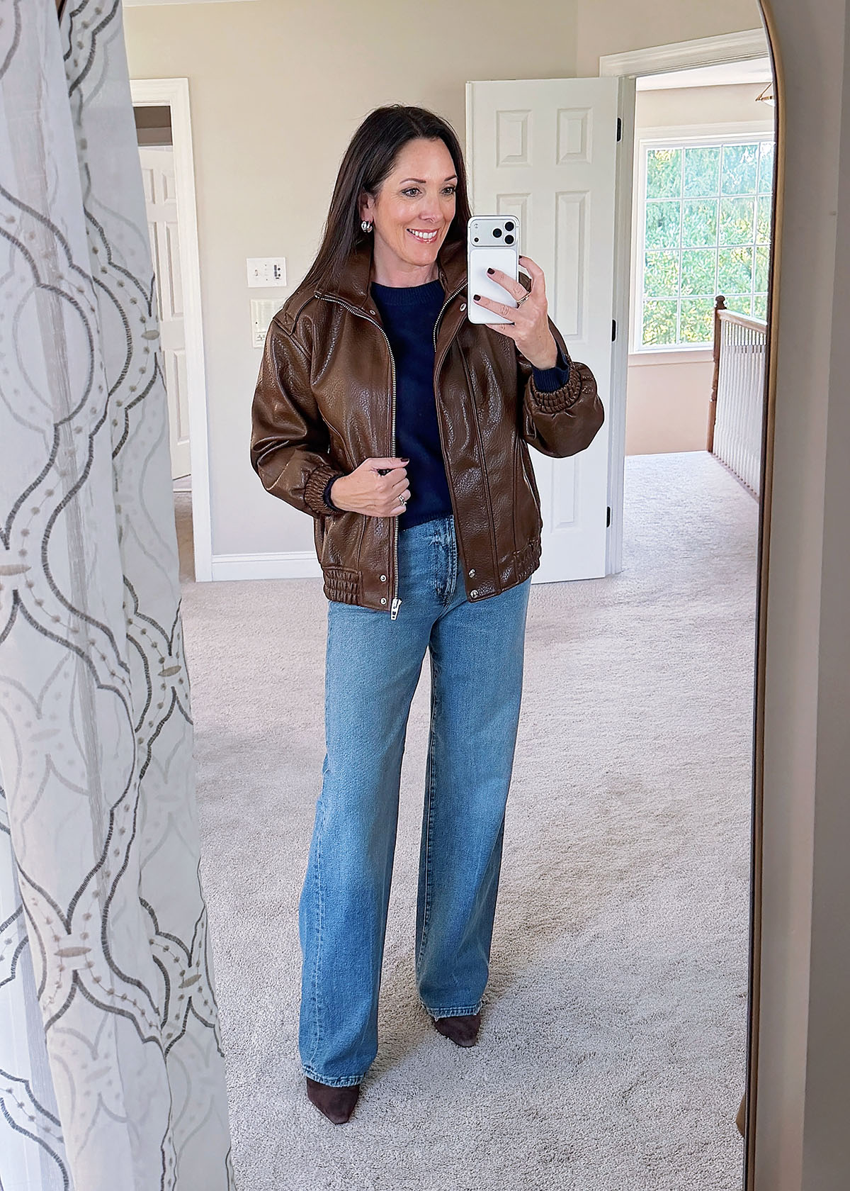 Vegan Leather Bomber Over a Sweater and Jeans christmas party outfit