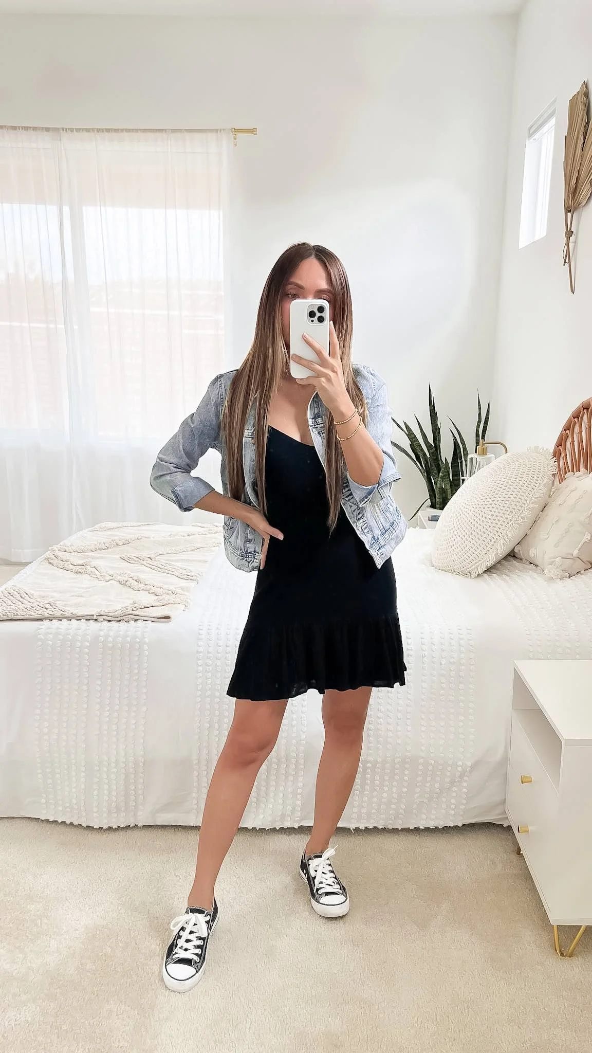 Black mini dress with a denim jacket and sneakers
