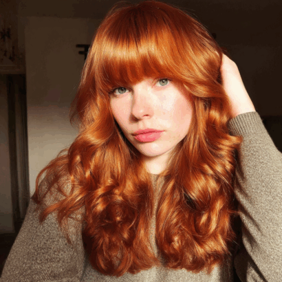 High-shine copper hair with bold full bangs copper hair color