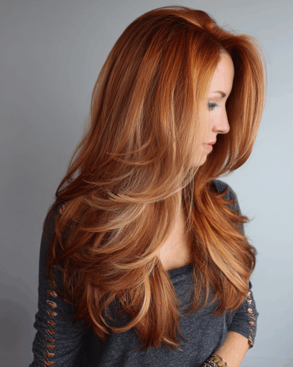 Sun-kissed copper balayage on long feathered layers copper hair color