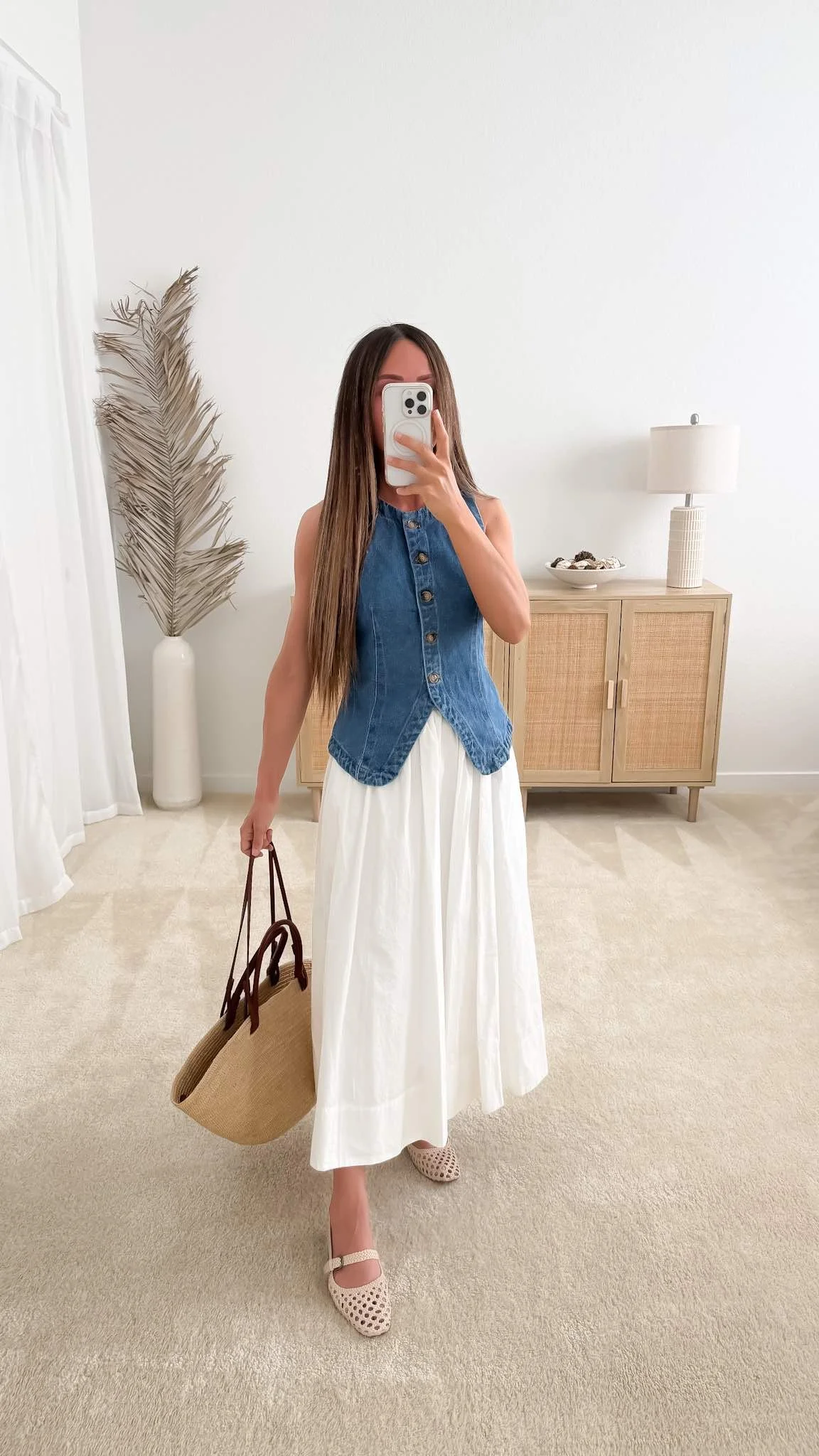 Denim vest over a flowing white midi skirt