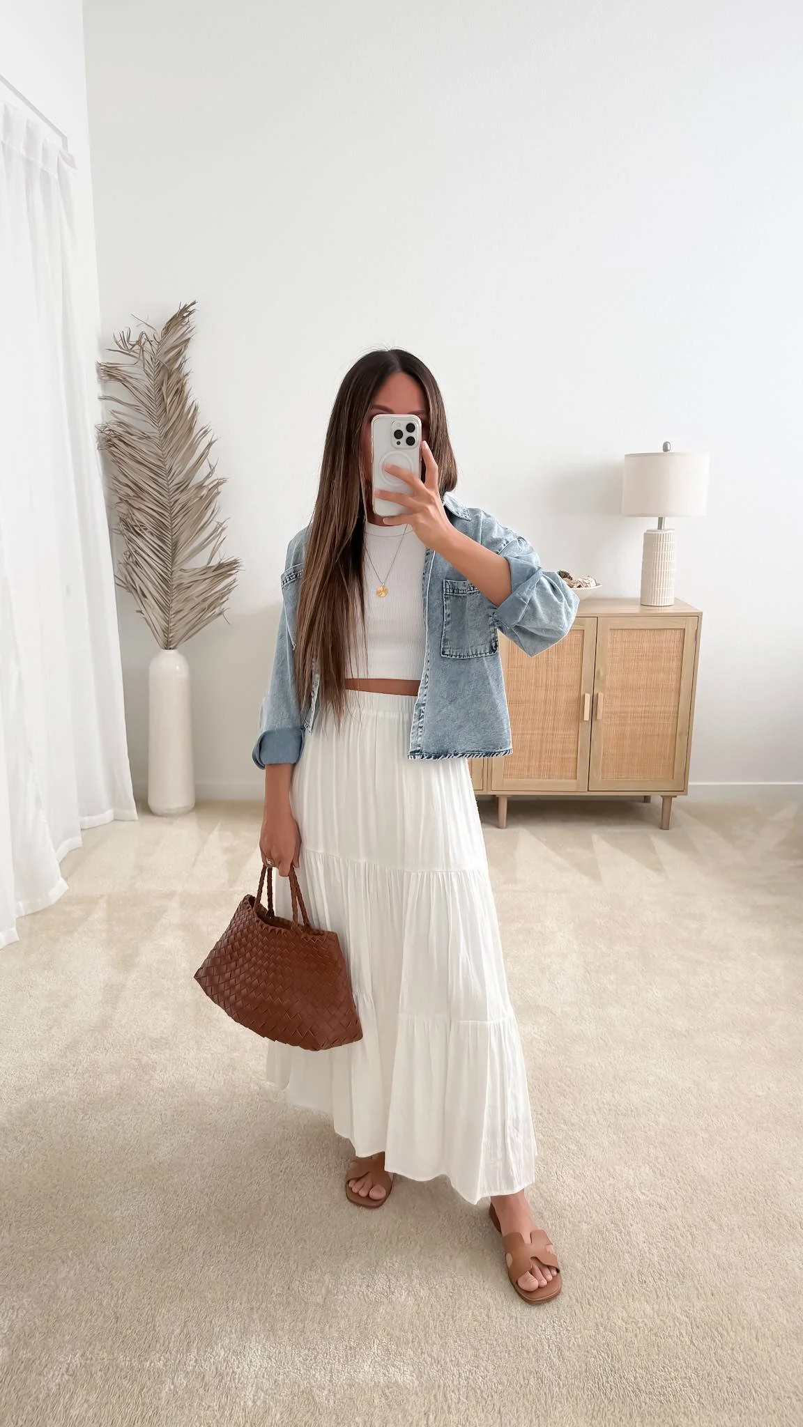 Denim jacket over a white tiered maxi skirt