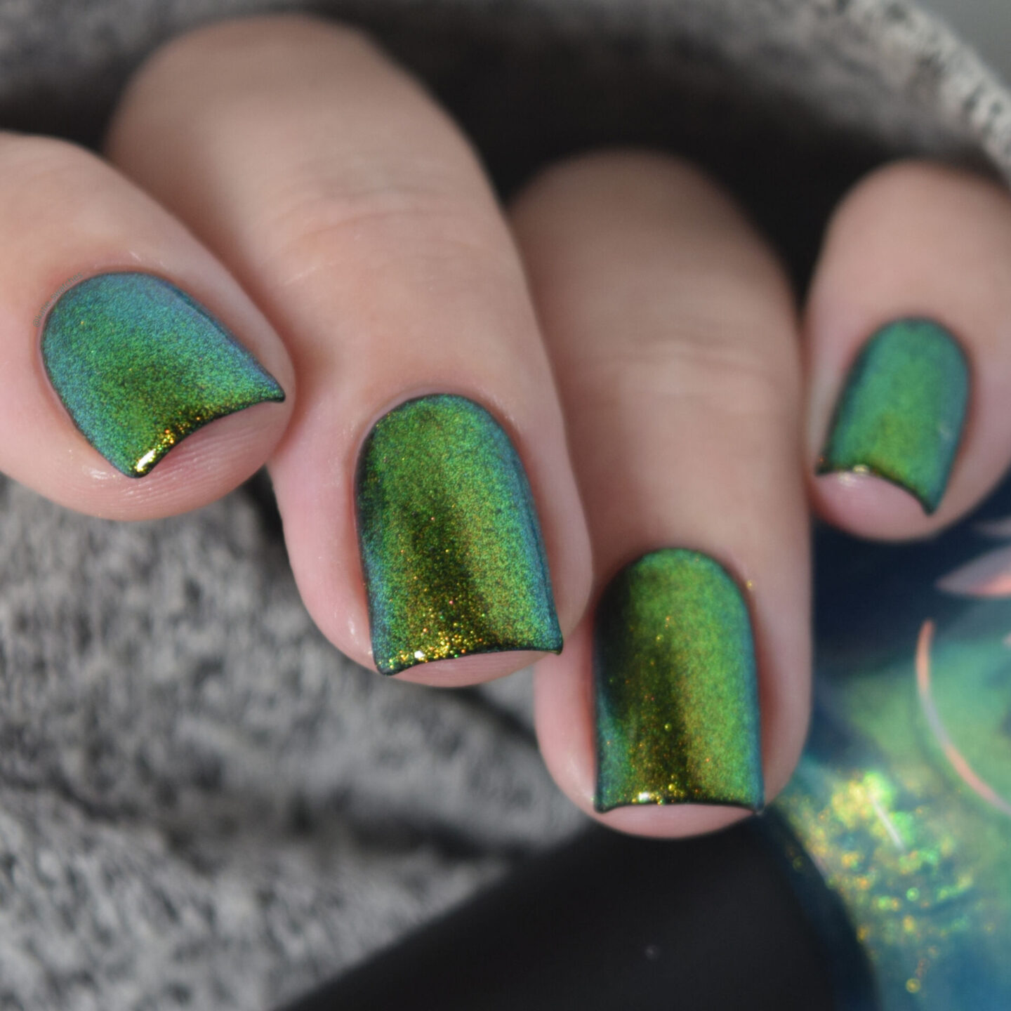 Emerald multichrome nail polish swatch over black
