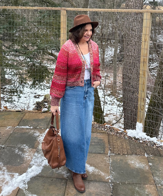 Denim maxi skirt worn with a cropped cardigan and tall brown boots