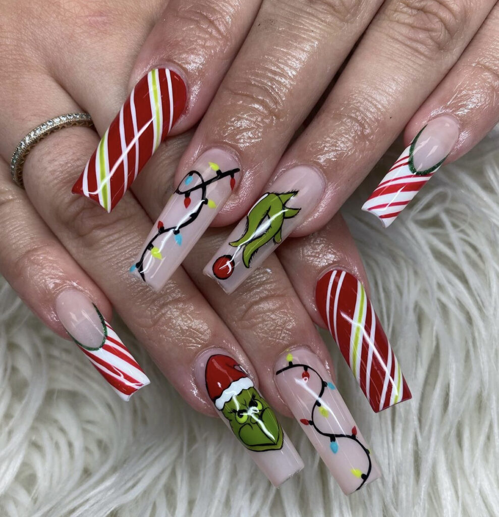 Striped Nails with a Grinch Accent grinch christmas nail design