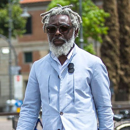 Dark locs decorated with silver cuffs and rings