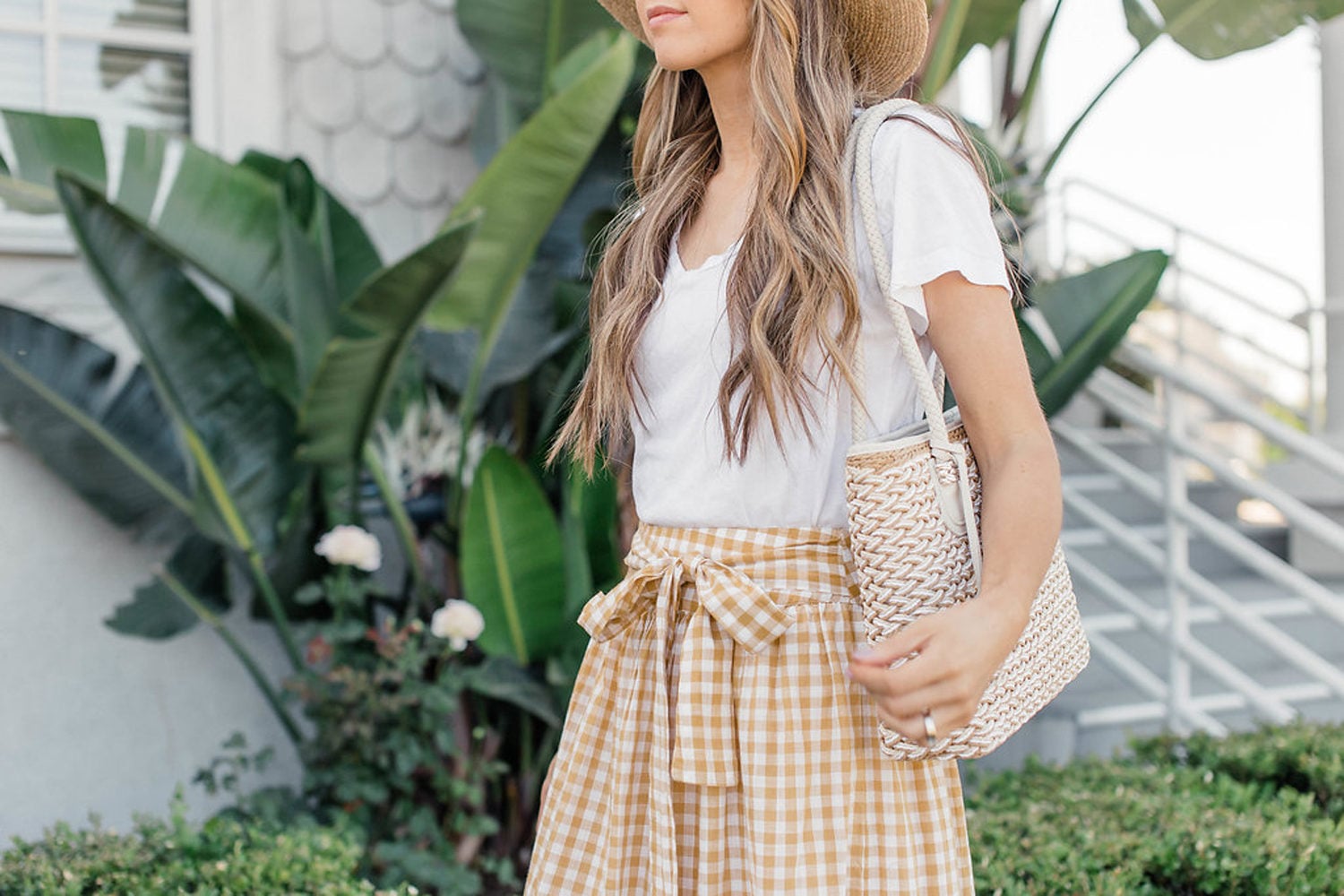 Yellow gingham skirt worn with a white tee and straw accessories