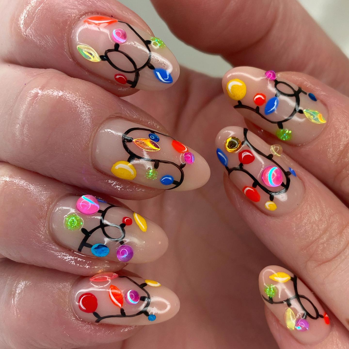 Glossy Bulb Strands on a Nude Base subtle Christmas nail design