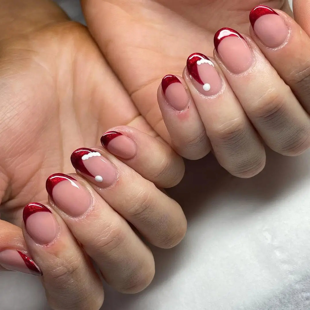 Nude Almond Nails with Glitter Tips and a Flat Pom-Pom santa hat nail design