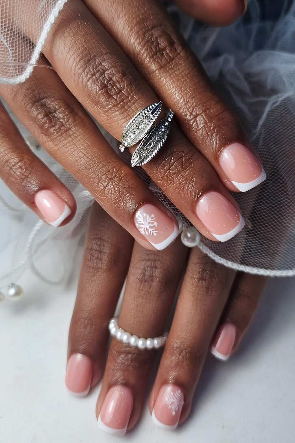 Short White French Nails with a Single Snowflake Accent elegant christmas nail design