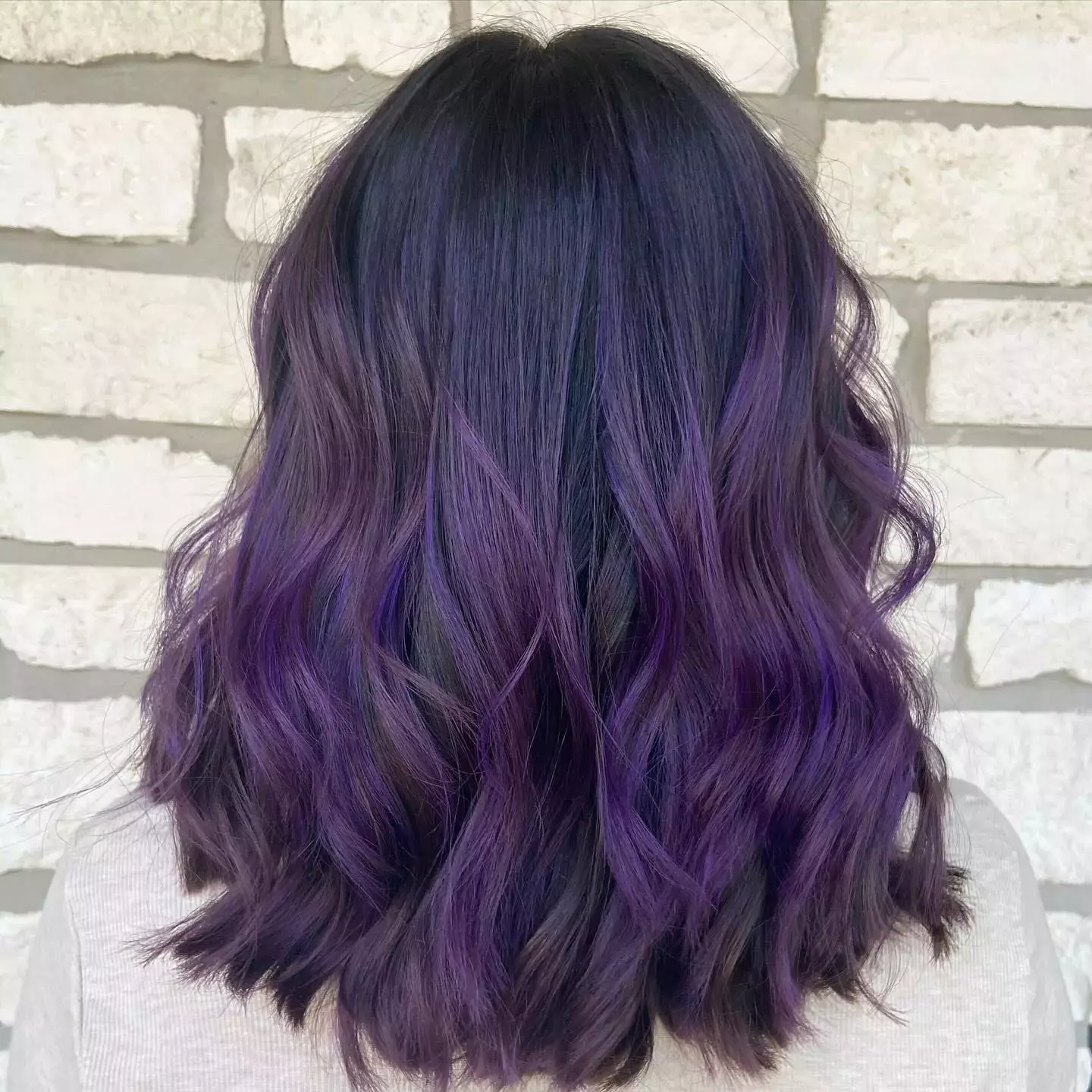 Subtle plum dimension on brunette hair