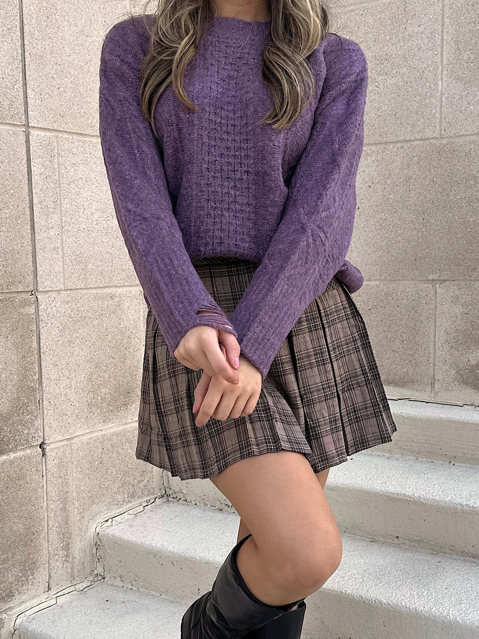 Knit sweater worn with a plaid skirt