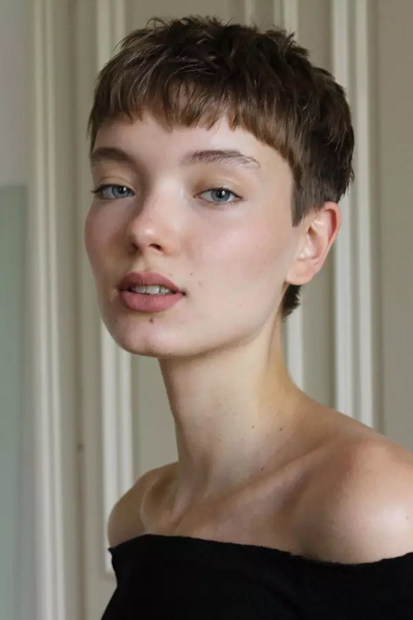 Woman with an undercut pixie and micro bangs